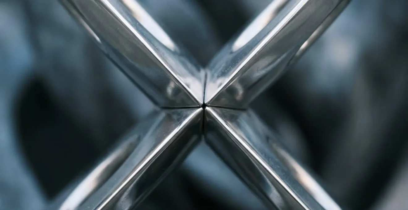 Vue macro sur des surfaces métalliques reflétant des textures abstraites évoquant l'échange et la réplication financière