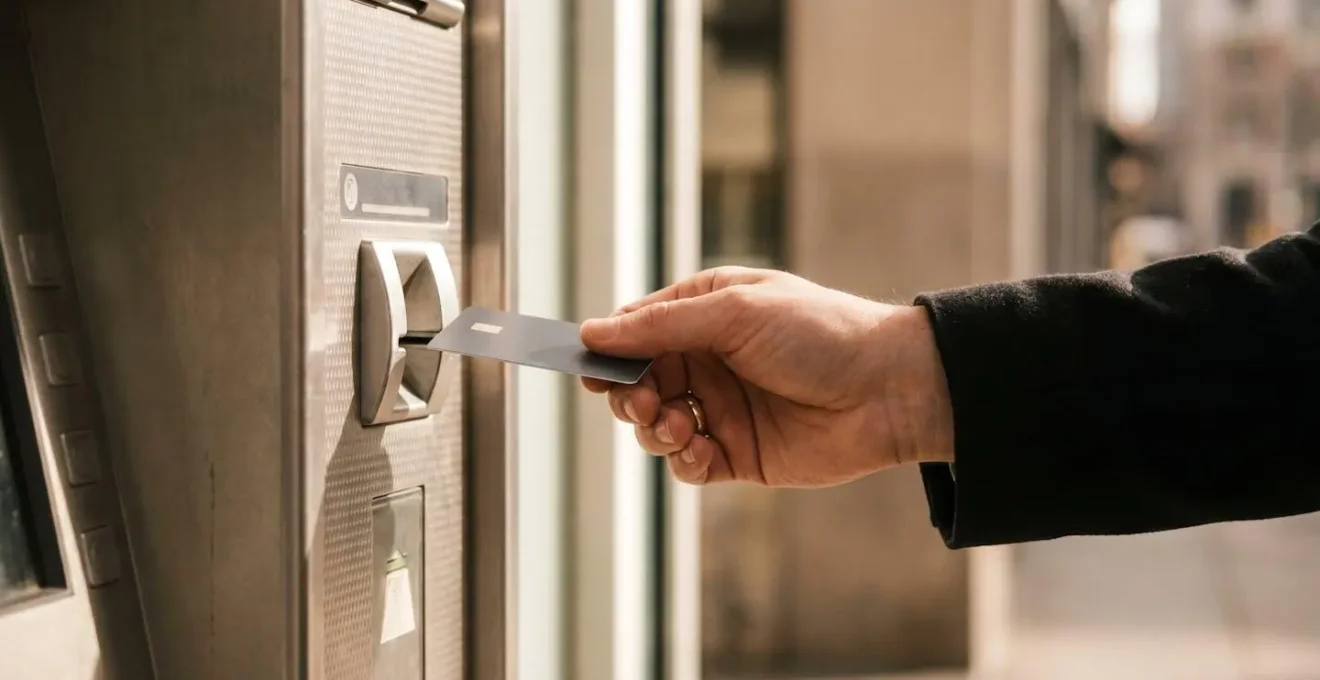 Personne utilisant sa carte bancaire à un distributeur automatique de billets moderne